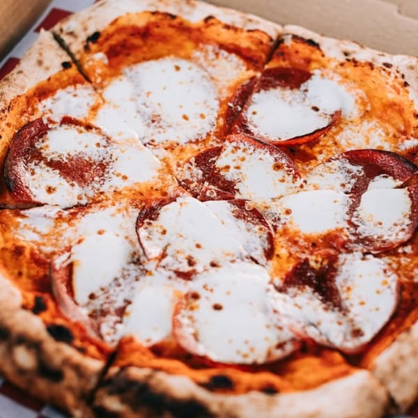 Close-up of a sliced pepperoni pizza from Captain's Pizza Company with melted mozzarella cheese.